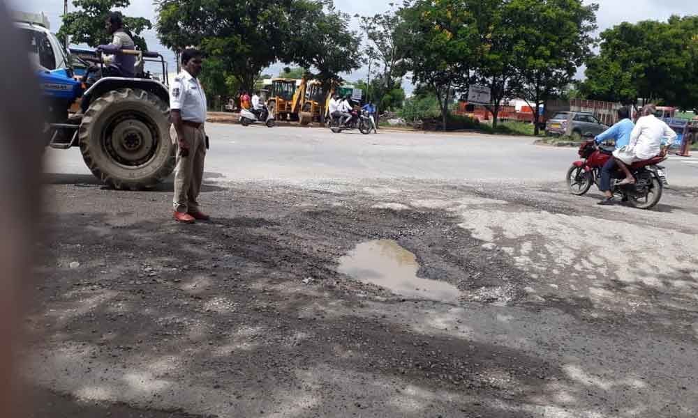 Traffic personnel fill up potholes
