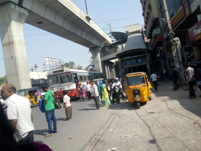 Lack of bus shelters; people wait on roads