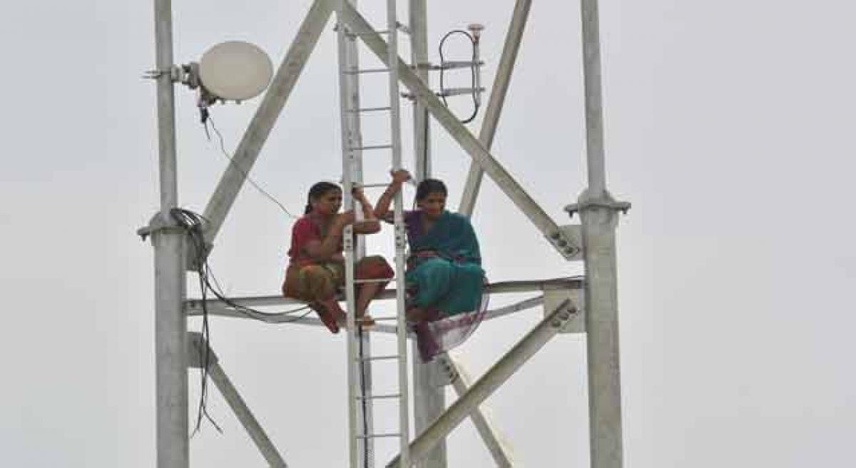 Women protest against cell tower, climb it