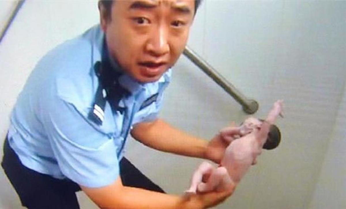Newborn stuck in public toilet in China, cop saves baby