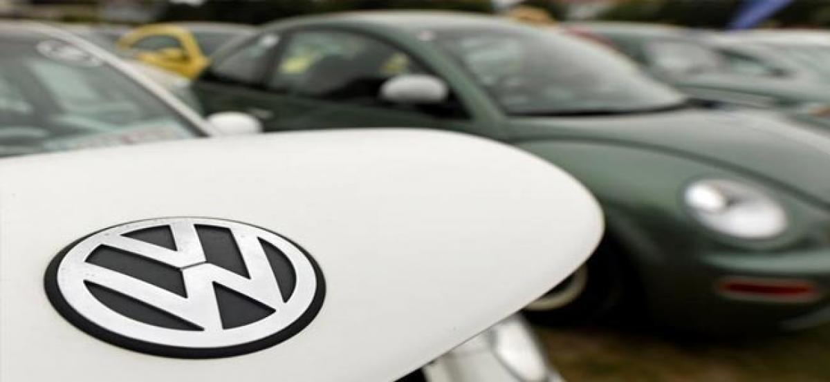 VW lowers spending plans as emissions costs weigh