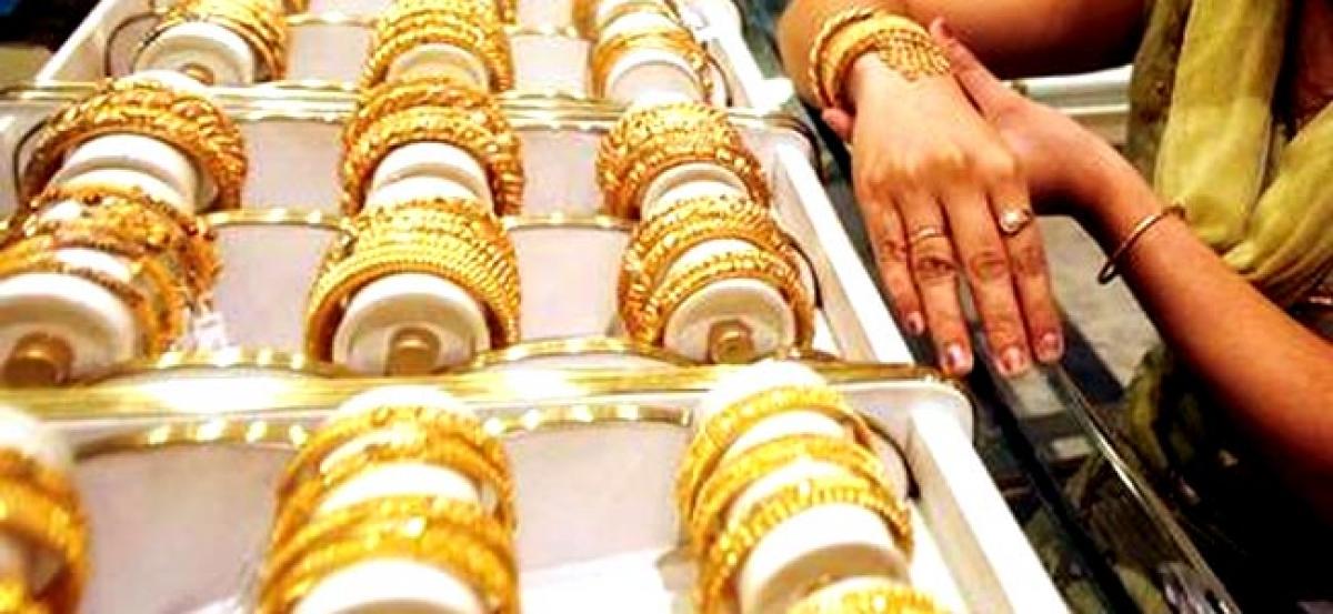 Gold slips on stronger dollar, profit-taking