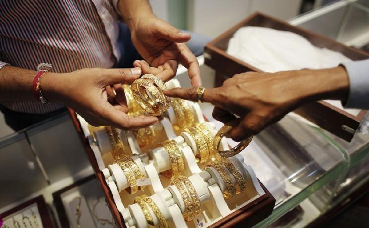 Gold retreats from five-month high as dollar rebounds