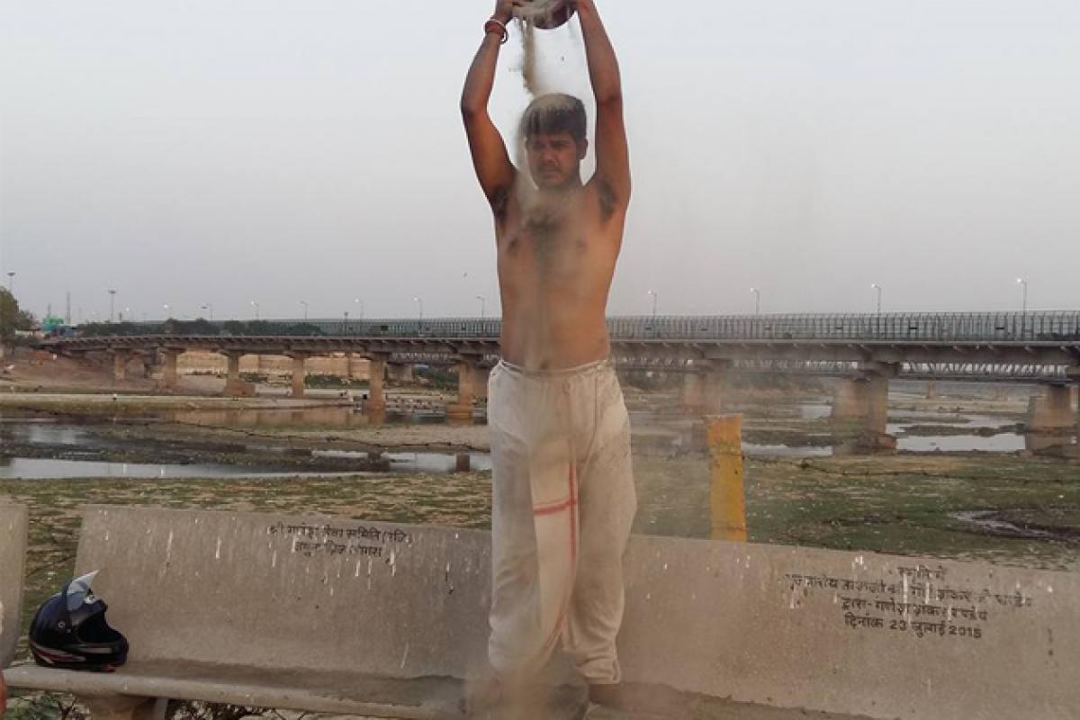 Activists take sand bath to protest Yamuna water crisis