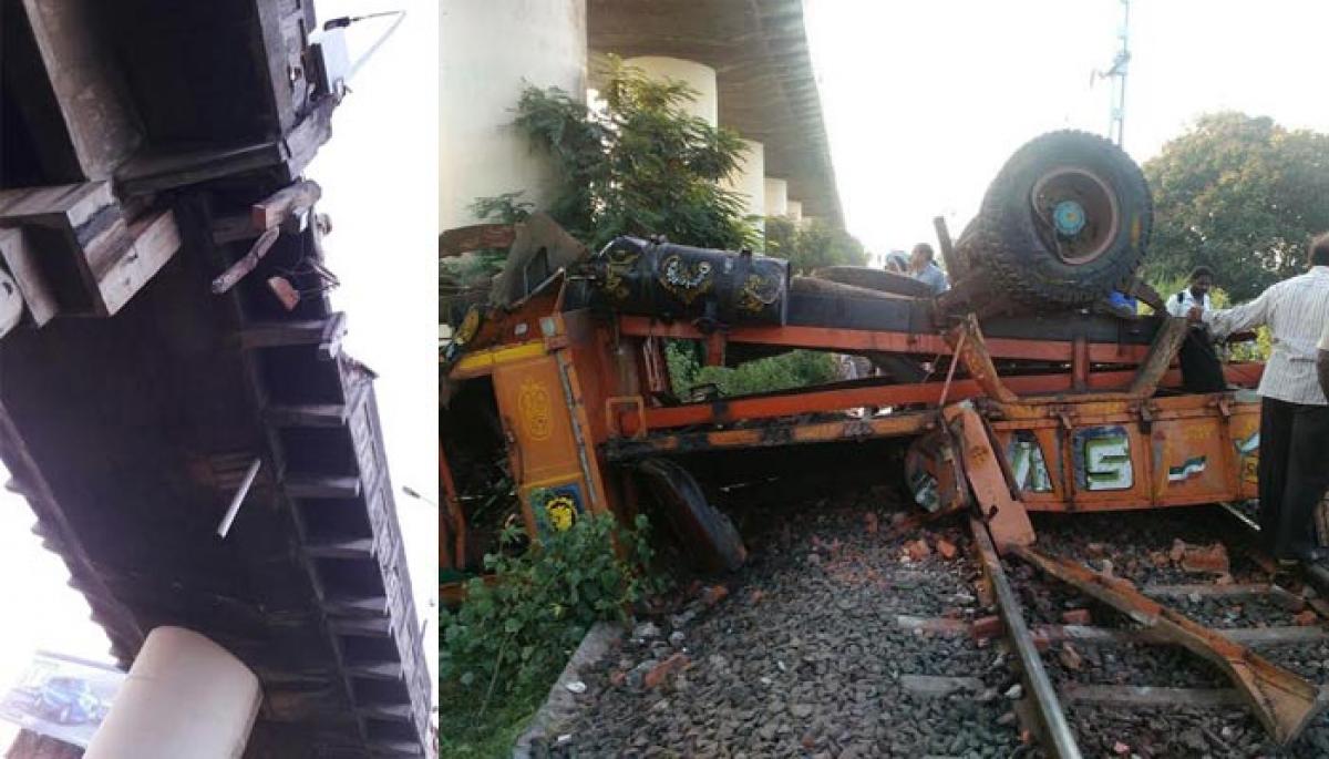 Truck topples from rail-road bridge