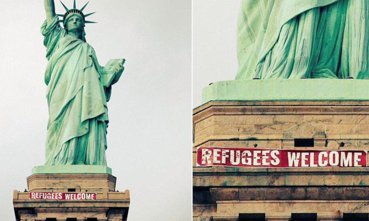 Banner reading Refugees Welcome unfurled at Statue of Liberty
