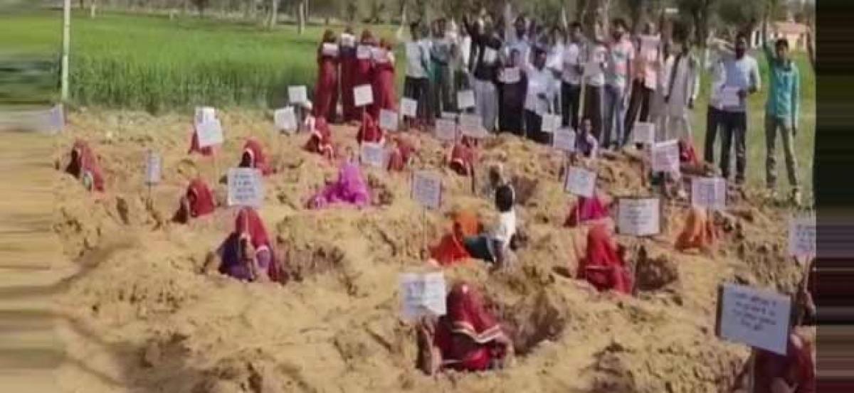 Farmers bury themselves in pits to protest in Rajasthan