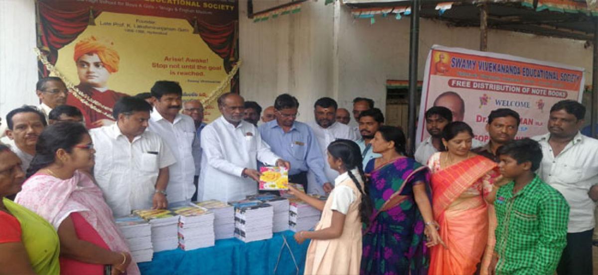 Lakshman distributes note books to students