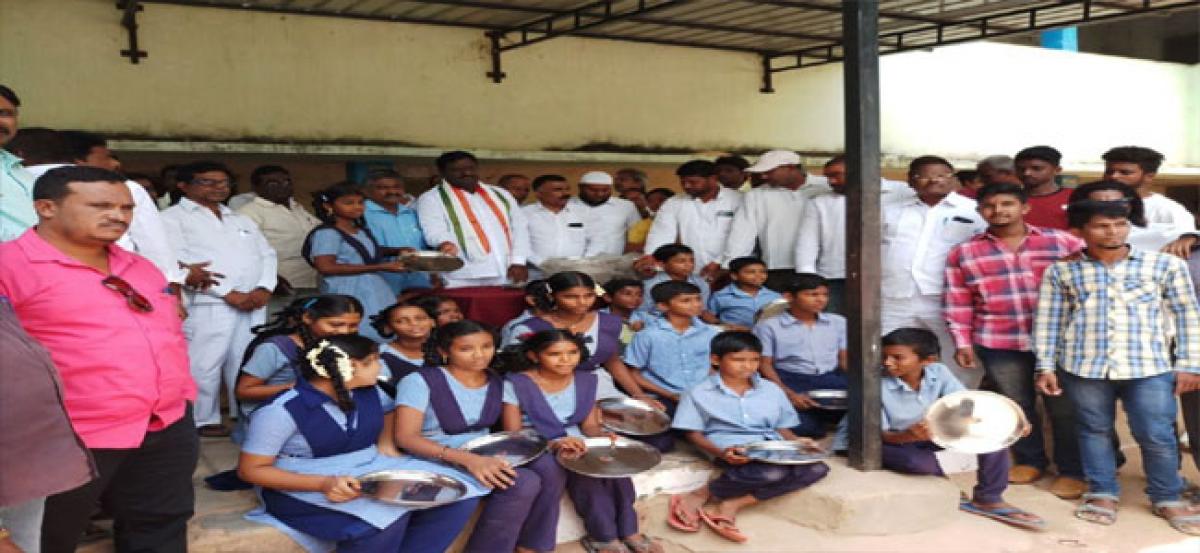 Congress leader distributes plates to students of ZPHS Neredmet