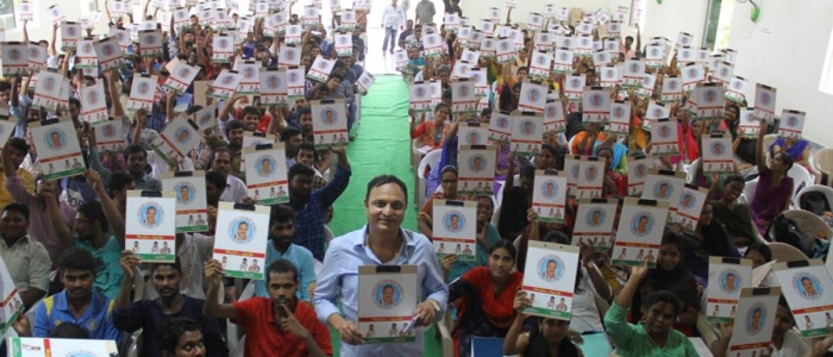 Bandari Lakshma Reddy distributes writing pads to candidates
