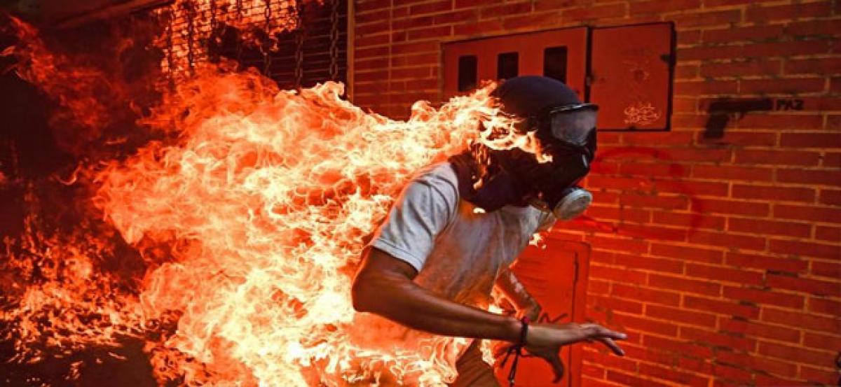 Gas mask on fire, hands waving in the air: Story behind the award-winning image of a Venezuelan man in flames