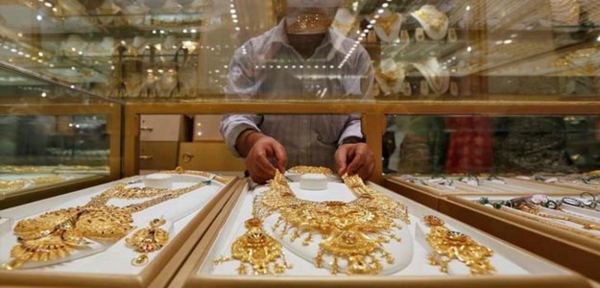 Gold eases on firm dollar, stronger equities