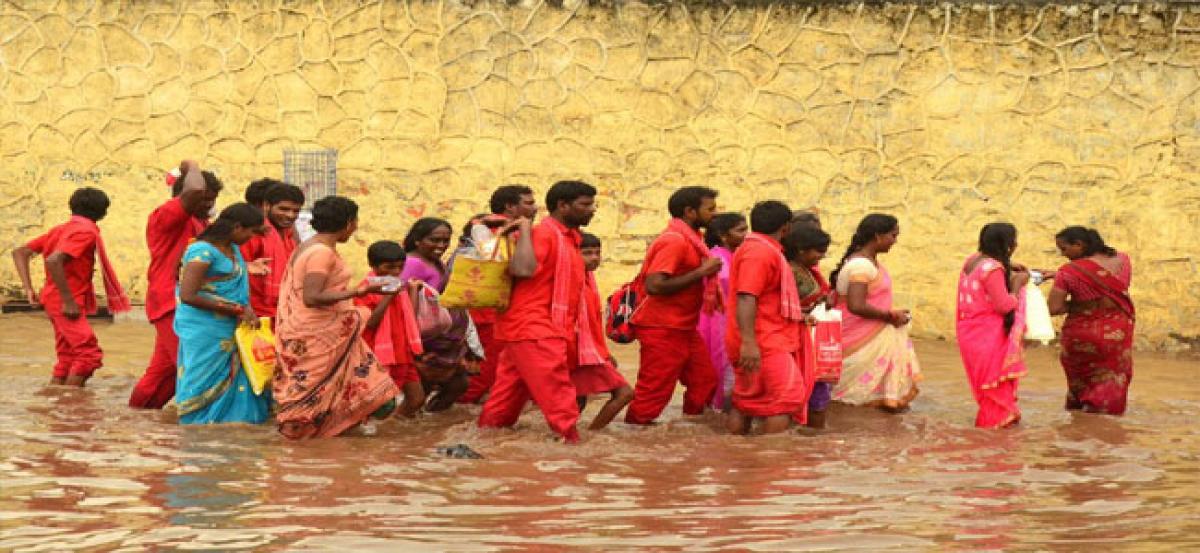 Devotees stuck in storm water on Krishna Lanka Highway