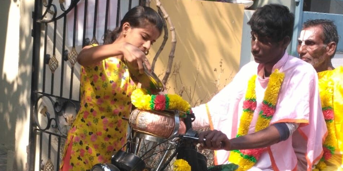 Ramadasu seeking bhiksha on moped