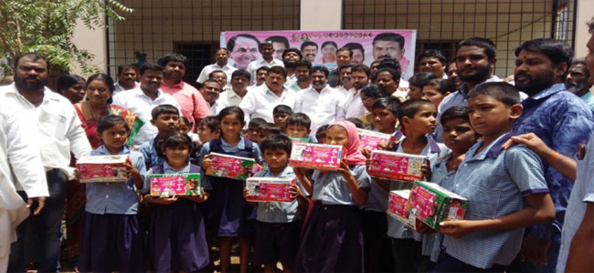 Muta Gopal distributes shoes to students at Bapuji Nagar